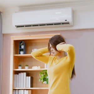 woman covering ears air conditioner strange noises